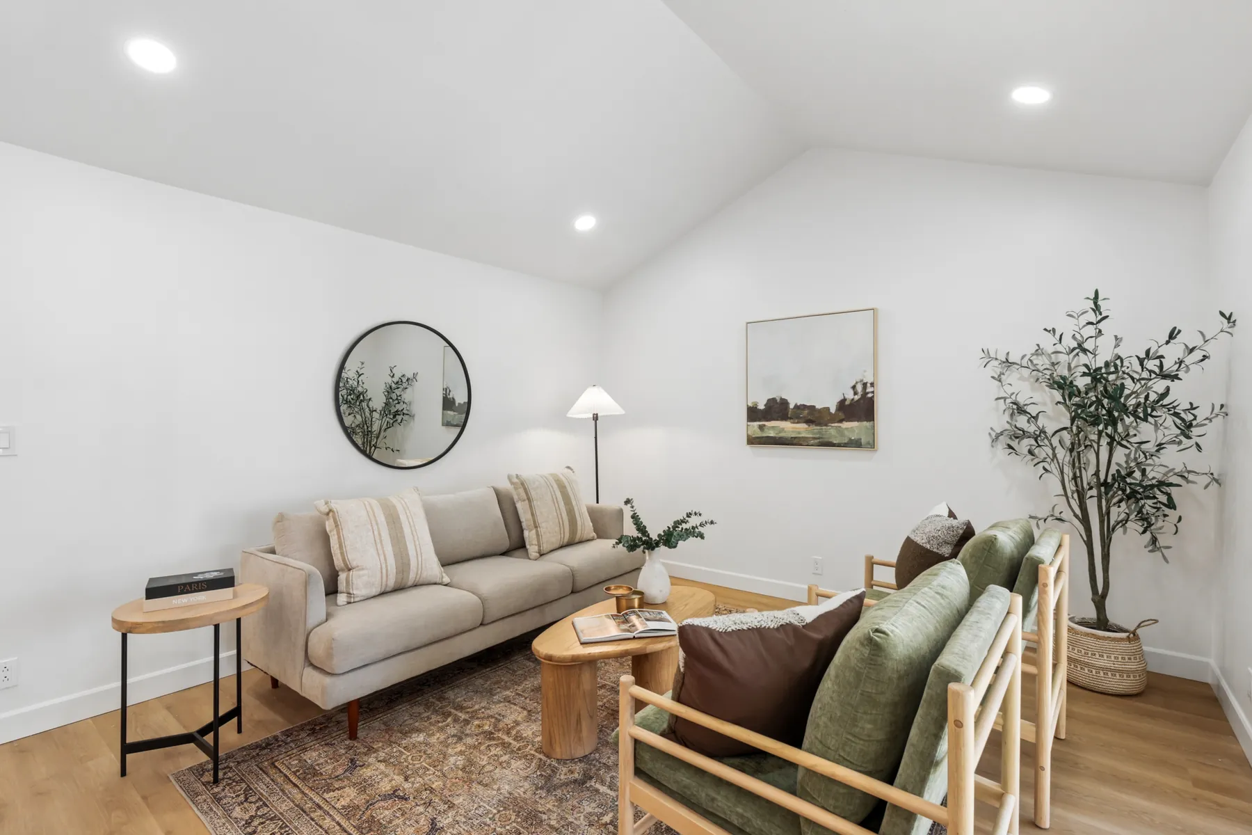 Living room with recessed lighting and wood-look plank flooring.