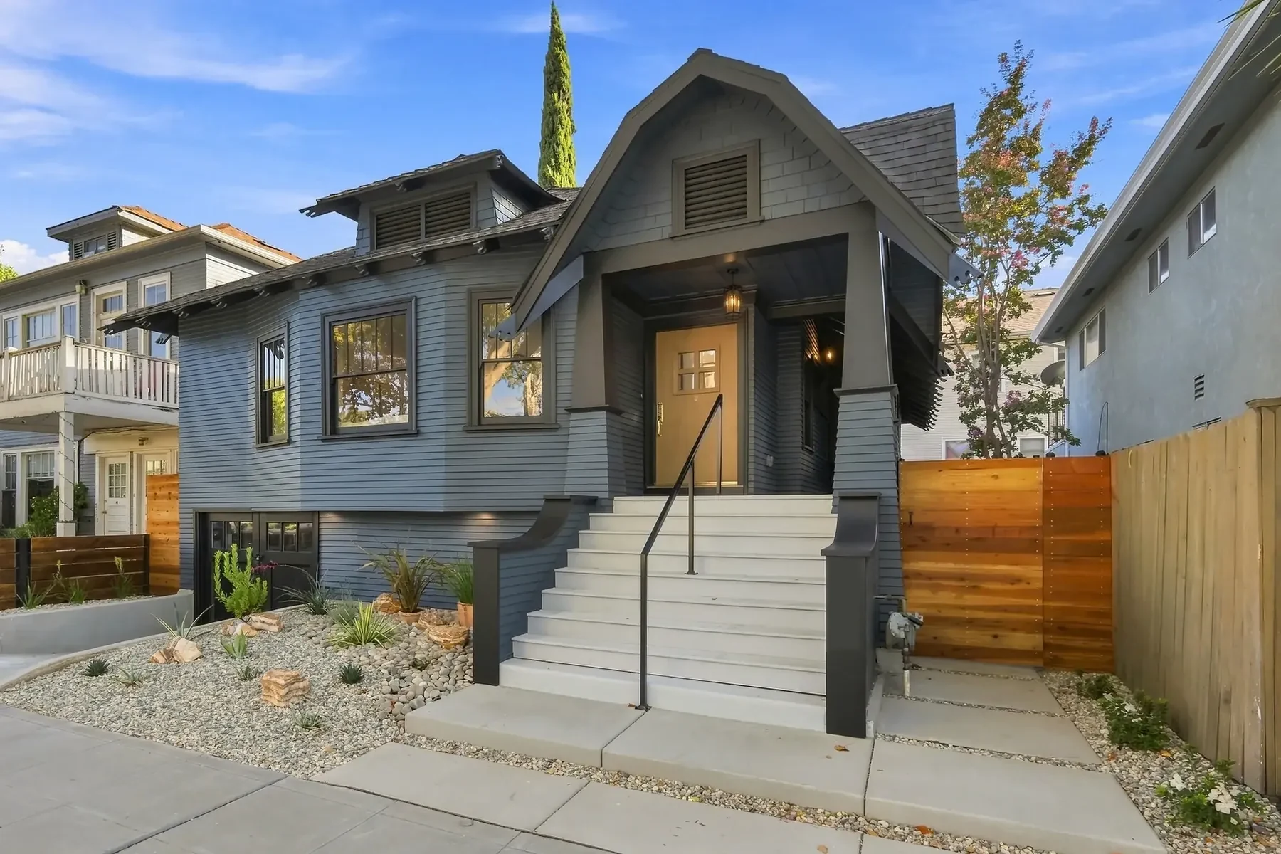 Raised entry with a new concrete stair and steel rail. Drought-appropriate planting replaced lawn across the full front yard.